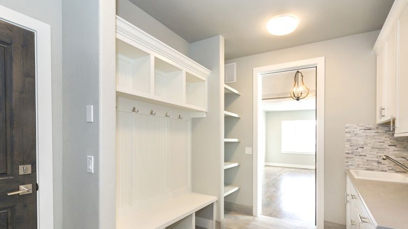 Ljus hall med sittbänk, krokar och öppna hyllor för förvaring