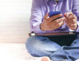 Person sitter med en smartphone i handen under en paus
