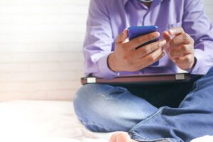 Person sitter med en smartphone i handen under en paus