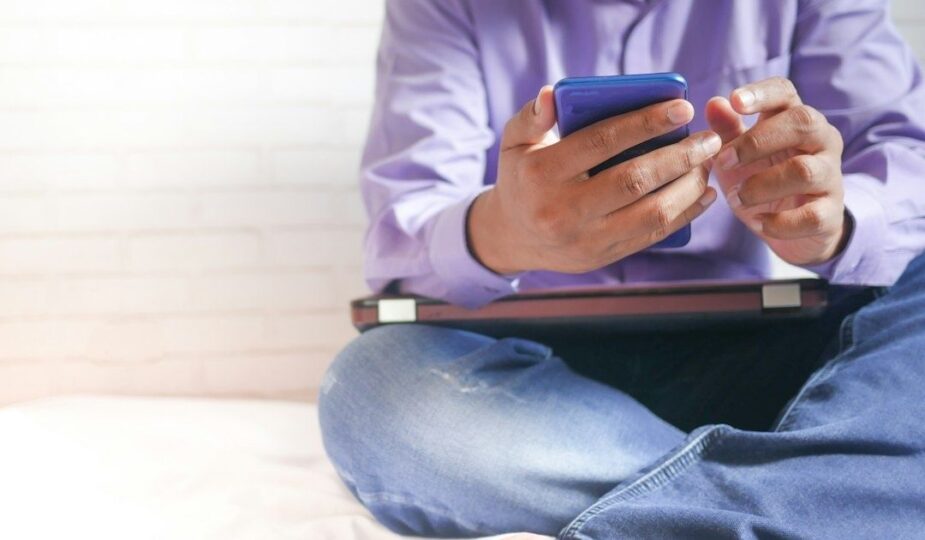 Person sitter med en smartphone i handen under en paus
