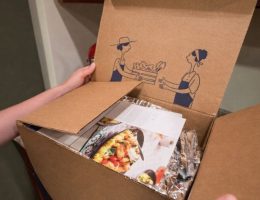 Öppen matkasse med recept, inplastade ingredienser och illustrationer på insidan