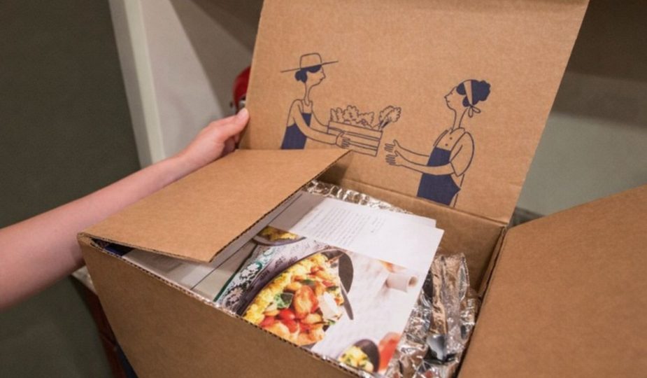 Öppen matkasse med recept, inplastade ingredienser och illustrationer på insidan